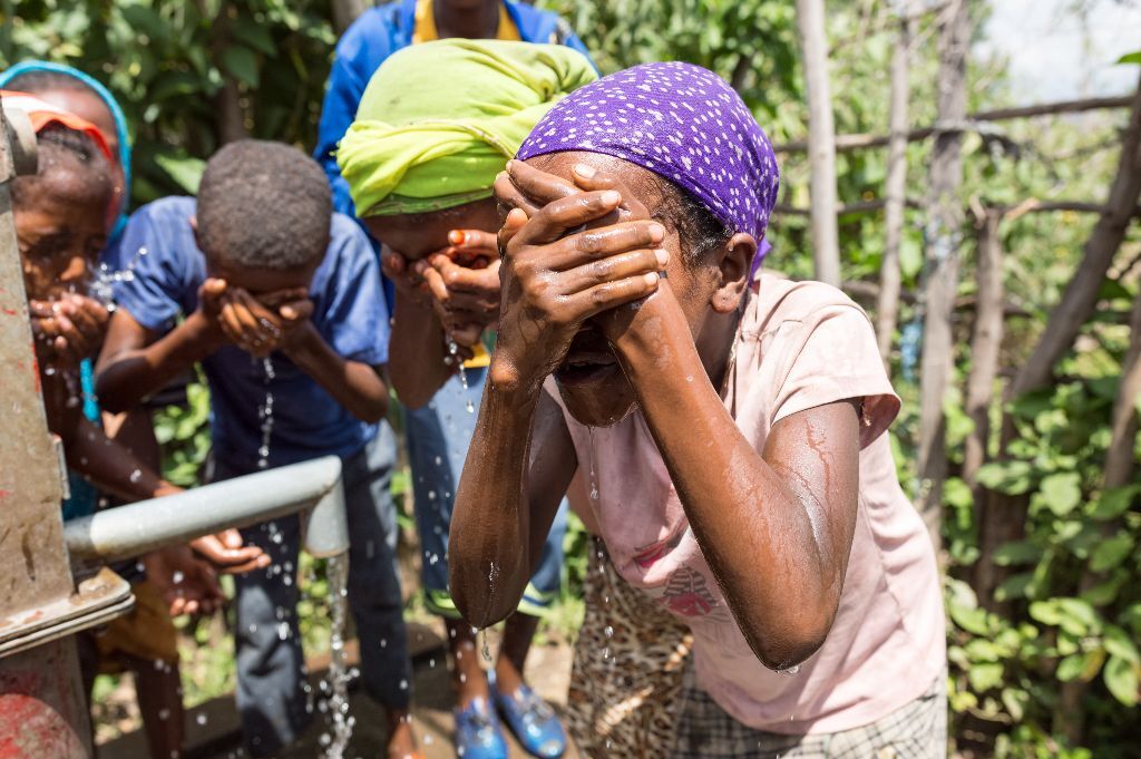 bambini al pozzo si lavano la faccia in Etiopia