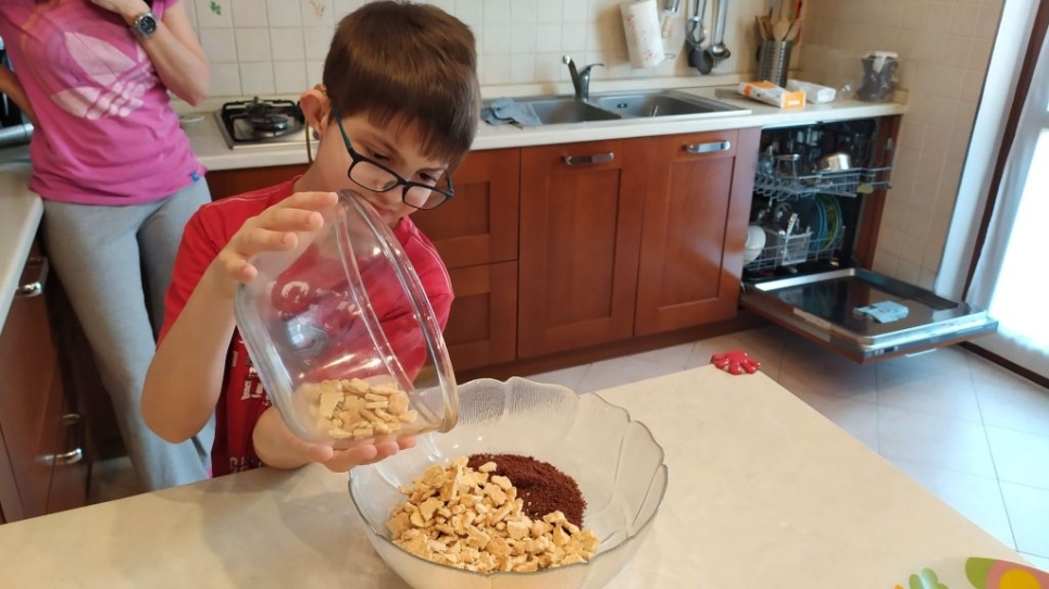 Mattia versa del cibo in una ciotola