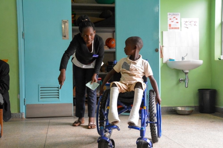 bambino con disabilità su sedia a rotelle in Uganda