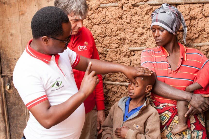un operatore fa una visita oculistica a un bambino in africa
