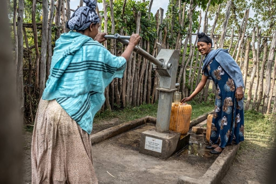 donne tirano acqua dal pozzo