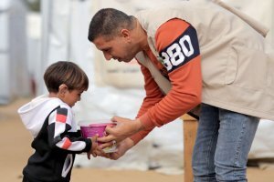 foto operatore mentre consegna un pasto caldo a un bambino