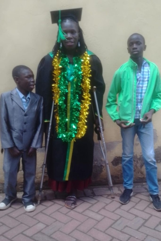 beneficiaria con stampelle insieme a due bambini