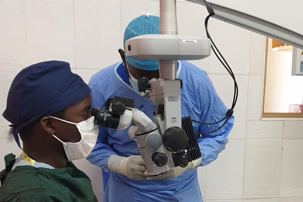 oculista in camice verde durante operazione