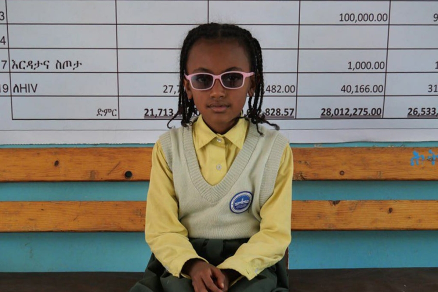 foto bambino seduto sui banchi di scuola