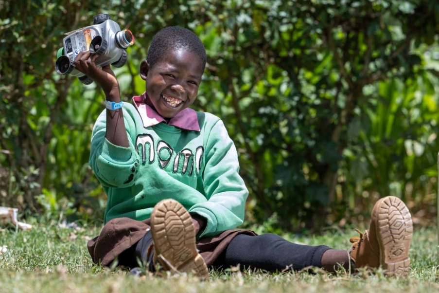 bambina seduta sul prato sorridente