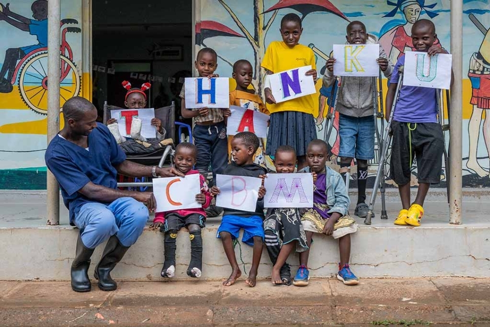 bambini tengono in mano dei cartelli in cui ringraziano cbm