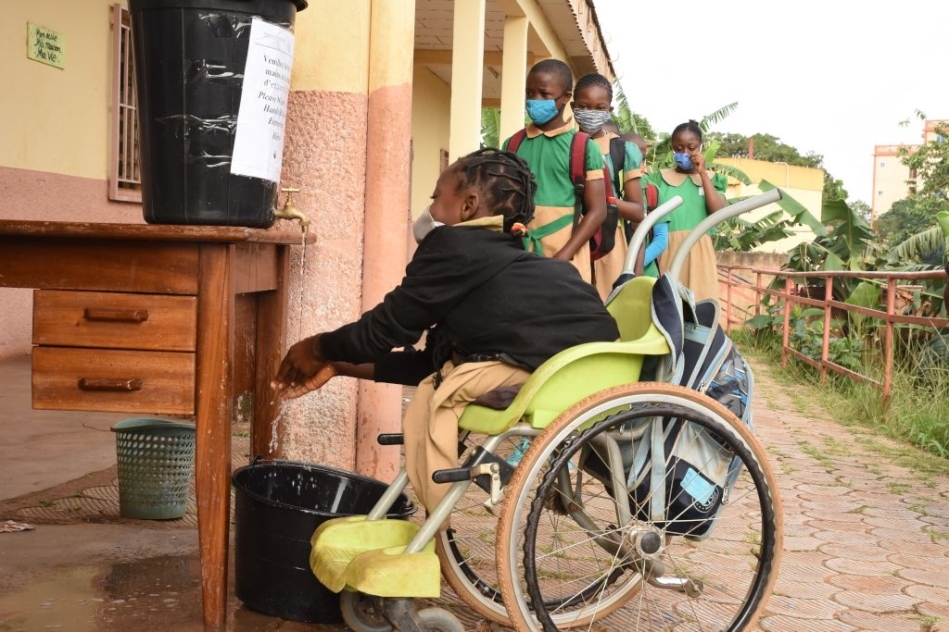 una bambina con disabilità si lava le mani a scuola