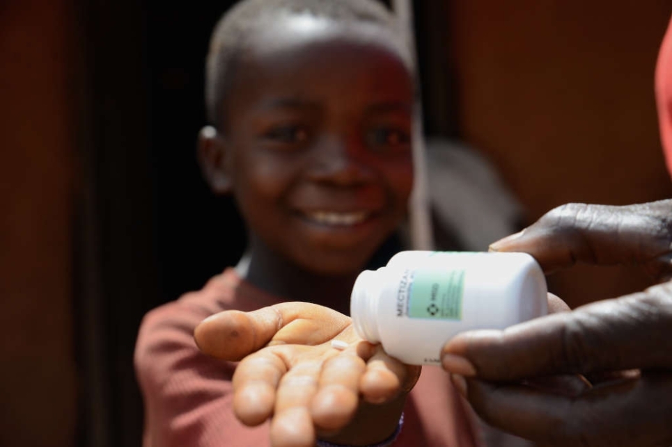 un bambino tiene tra le mani una pillola di ivermectina