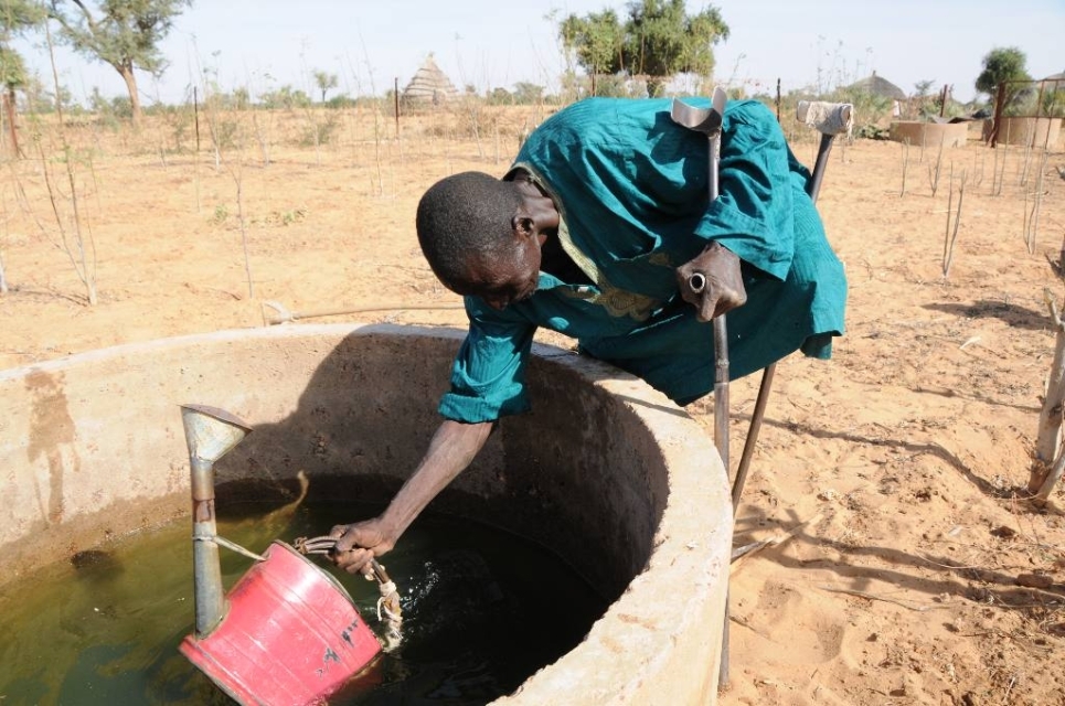 Persona con disabilità al pozzo in Africa